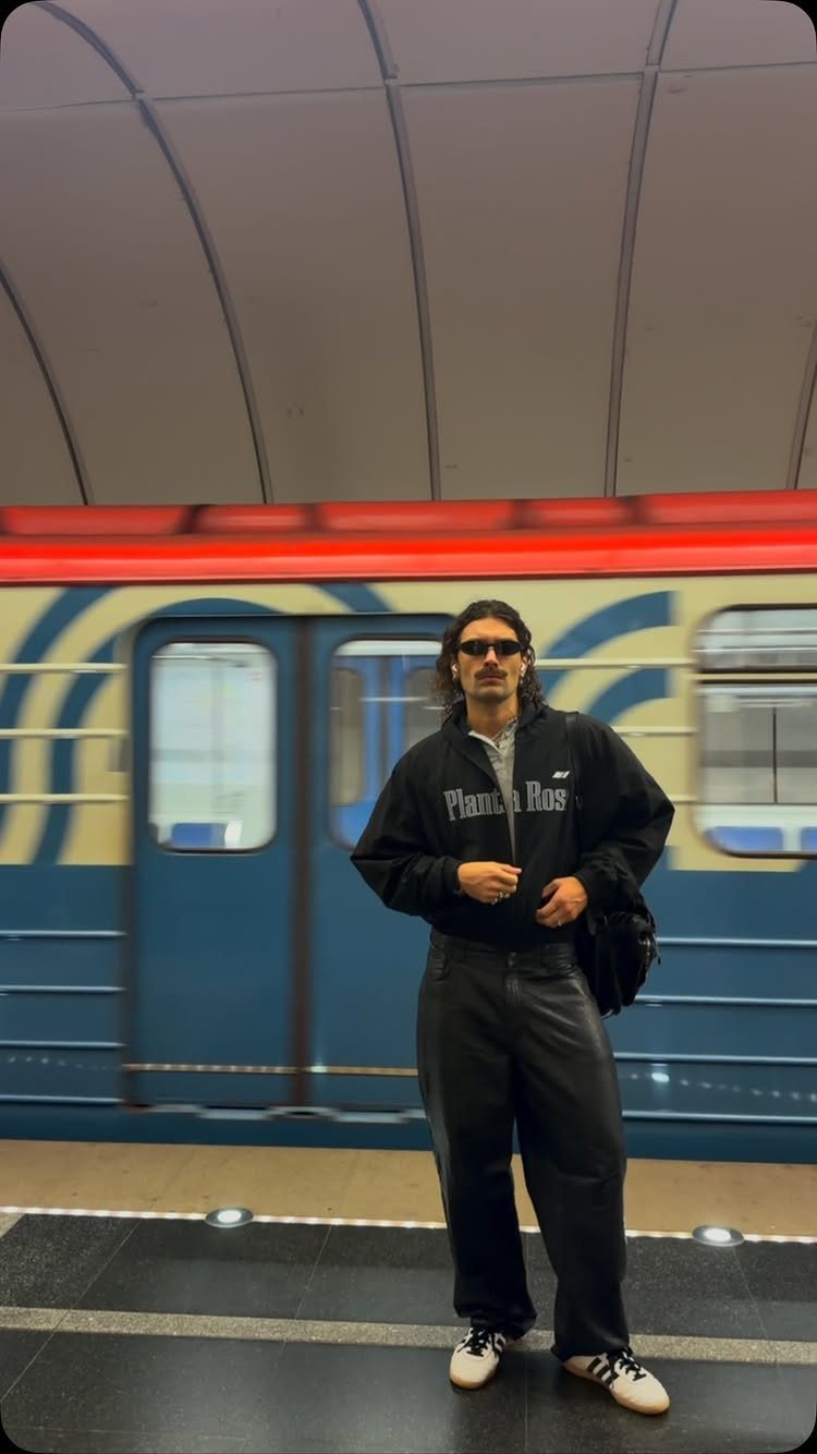Man in black hoodie and leather pants wearing white adidas samba sneakers