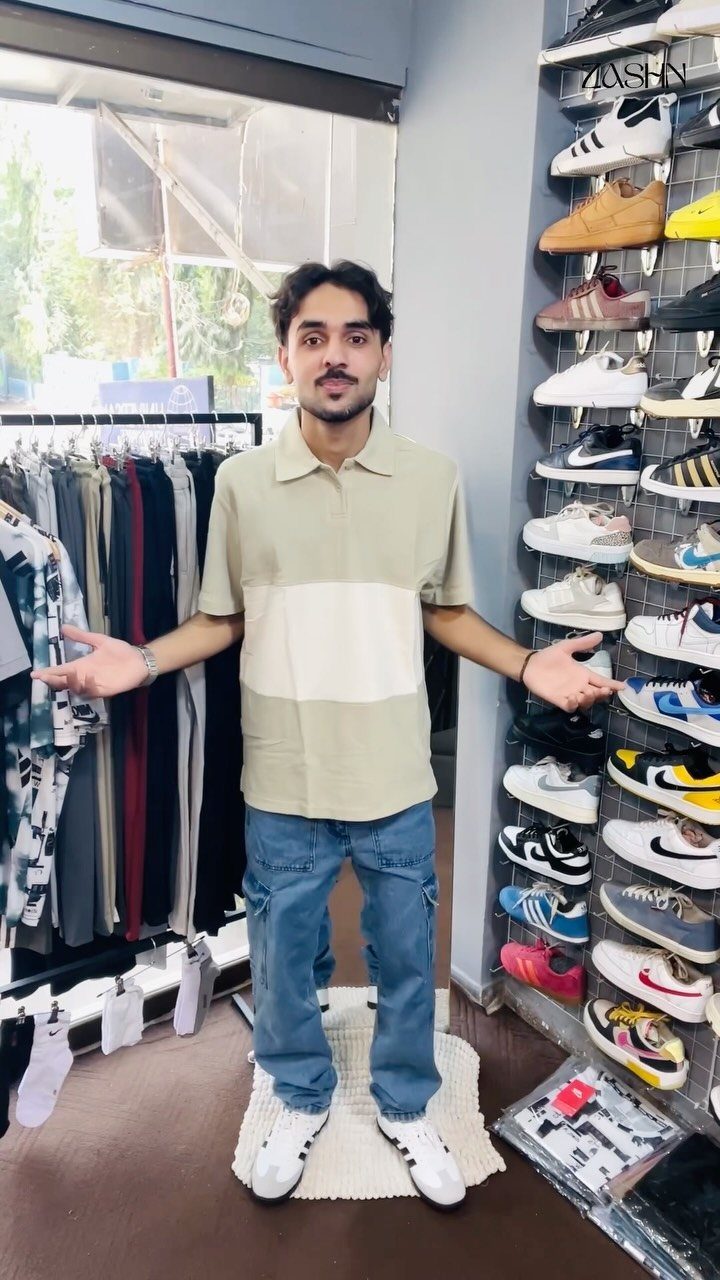 Man wearing a green polo, blue cargo pants, and white Adidas Samba sneakers.