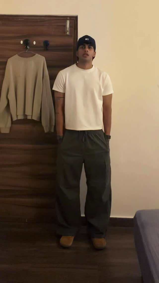Man wearing a fitted white t-shirt and olive green baggy cargo pants.