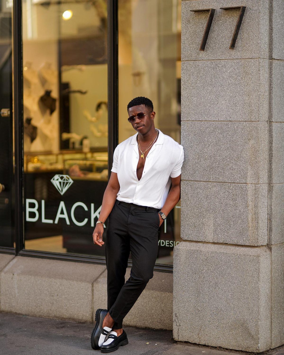Man in white shirt and black trousers wearing black loafers and white socks.