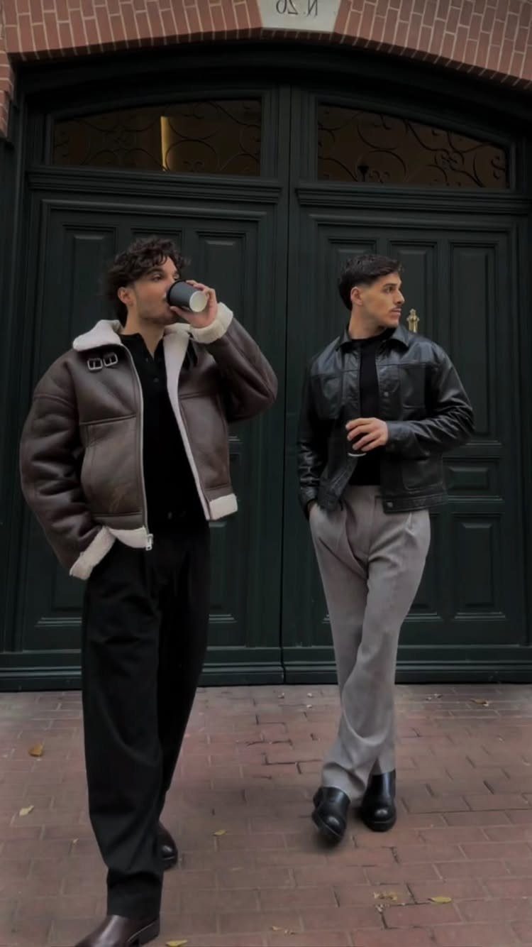 Two men in stylish jackets and trousers wearing dark boots outdoors