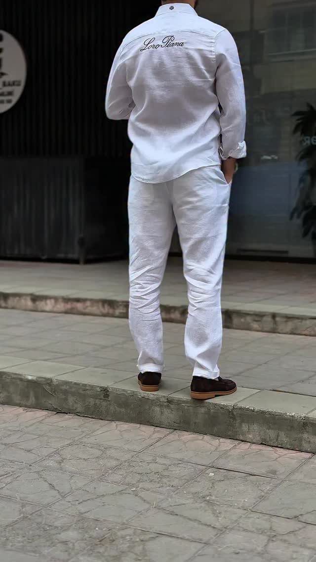 Man wearing white shirt and trousers with dark brown suede loafers from behind