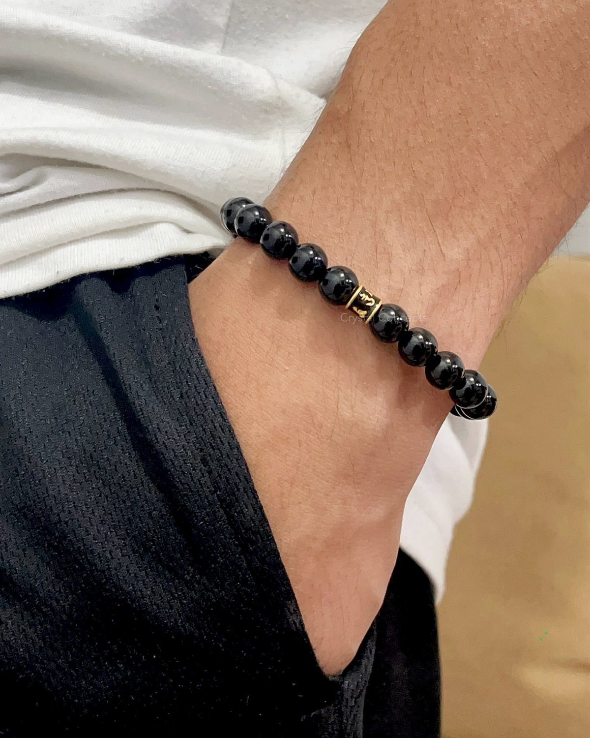 Black crystal bead bracelet with gold accent on a man's wrist