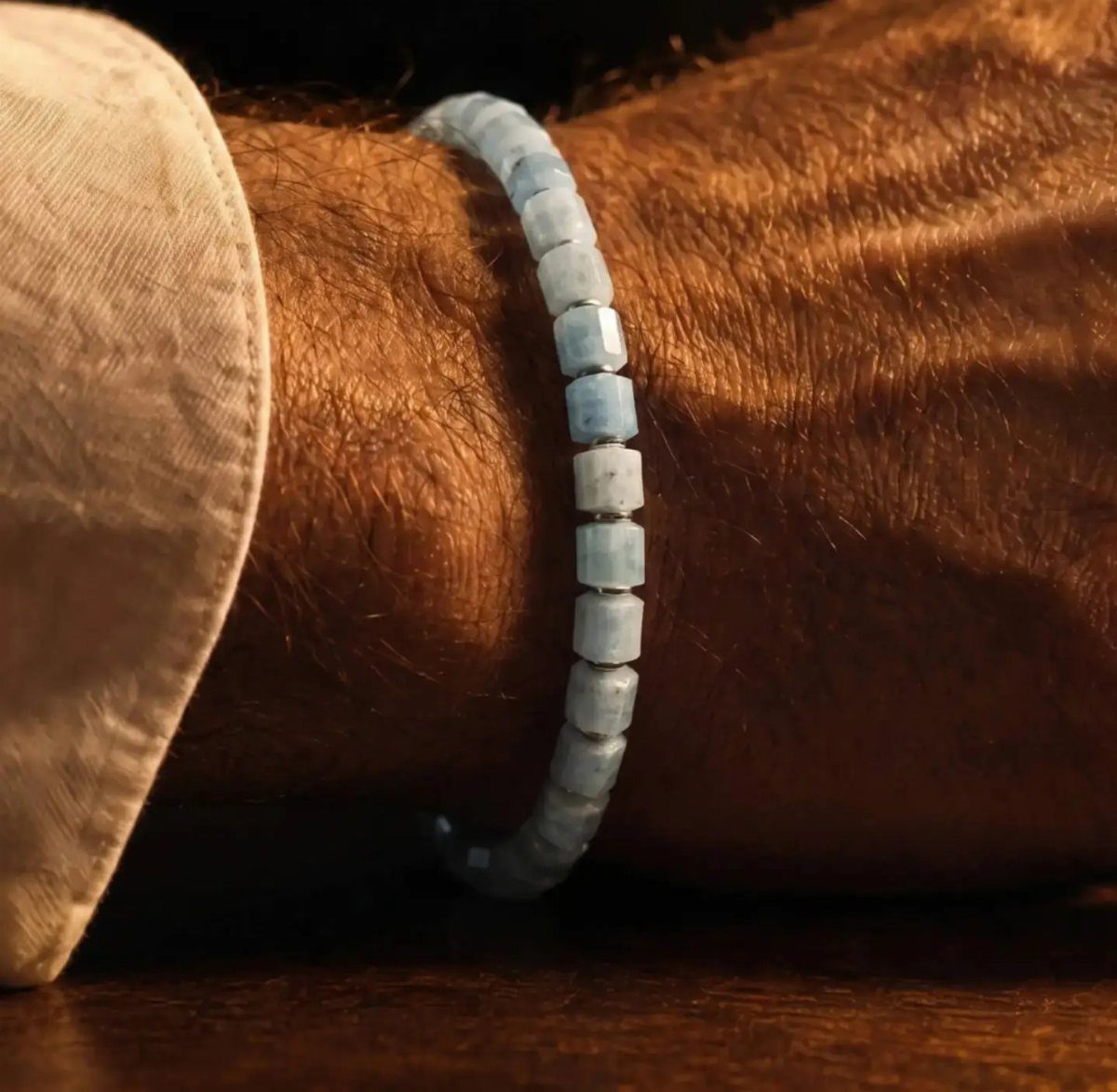 Light blue square crystal bead bracelet worn on a man's hairy wrist