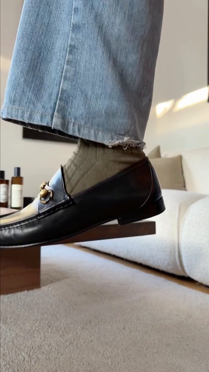 Light blue jeans and black leather bit loafers with olive green socks.