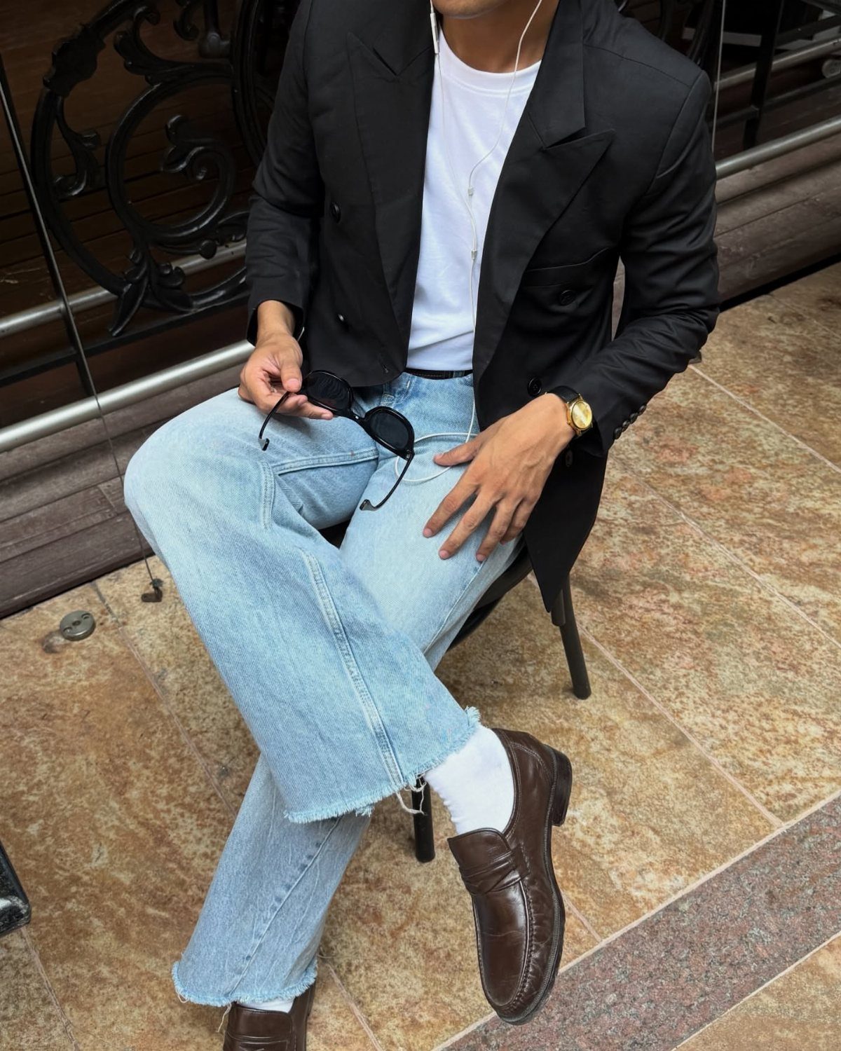 Man wearing light blue jeans and dark brown leather loafers with white socks