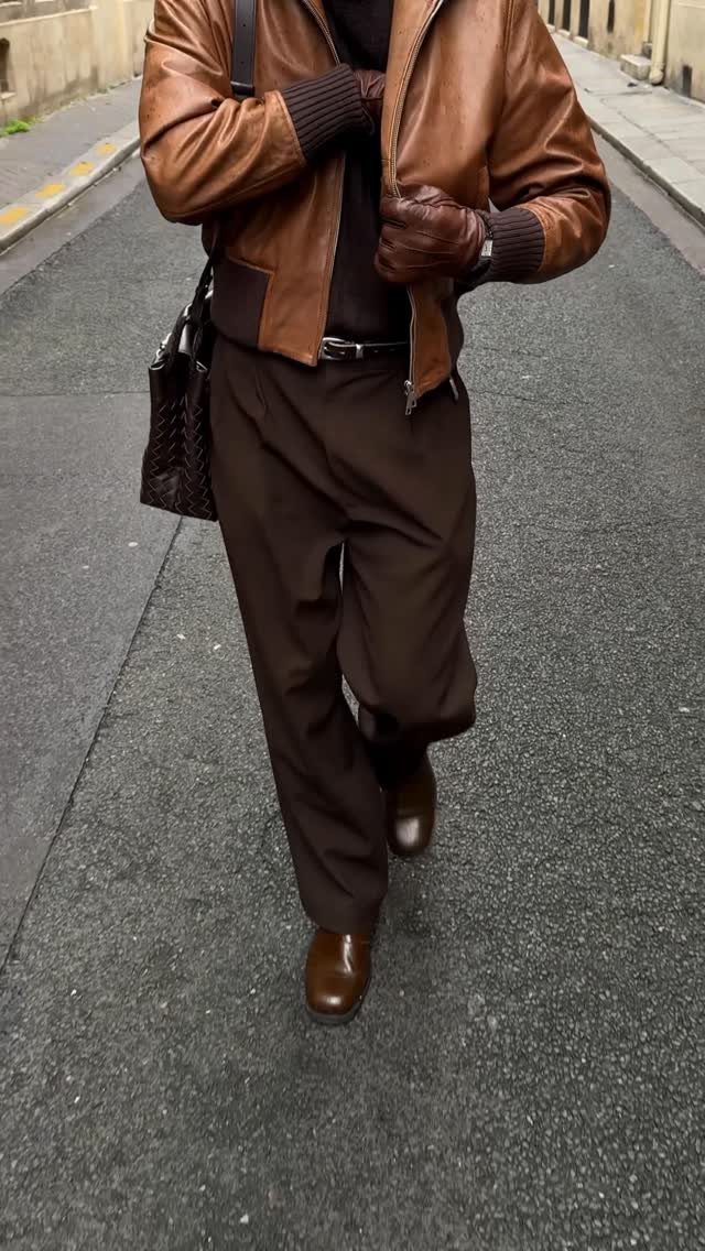 Man in brown leather jacket and trousers wearing brown leather dress shoes.