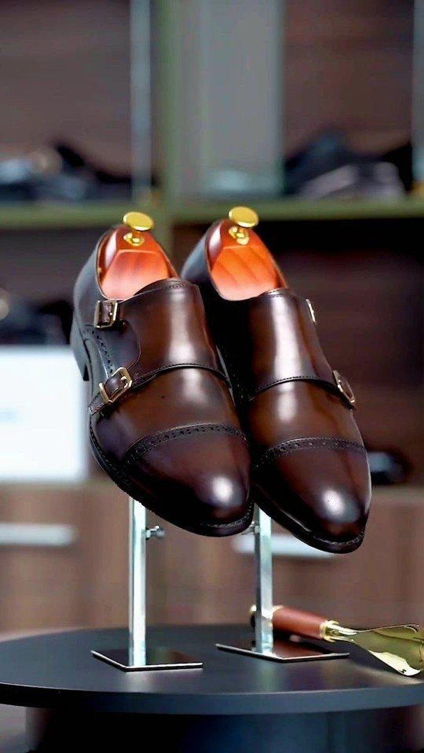 Brown leather double monk strap shoes on display stands in a store