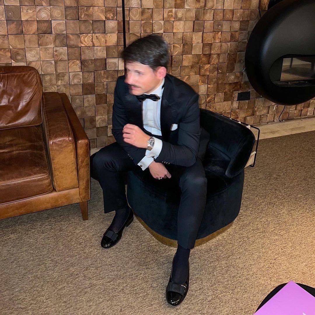 Man in a black tuxedo wearing classic black patent leather dress shoes