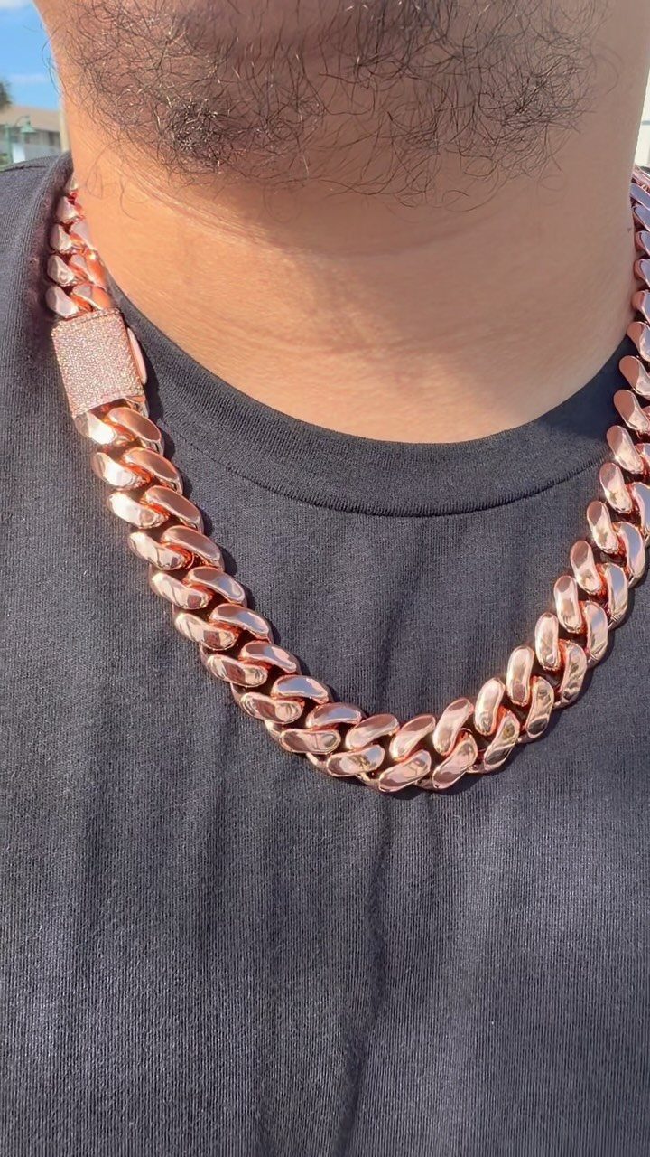 Rose-gold Cuban link chain necklace worn by a man over a black shirt