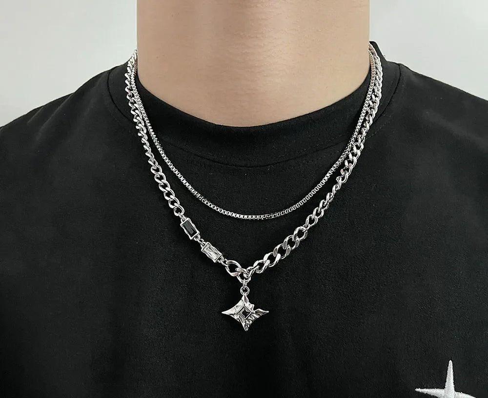 Two silver necklaces, one thin and one thick with a star pendant, on a man.