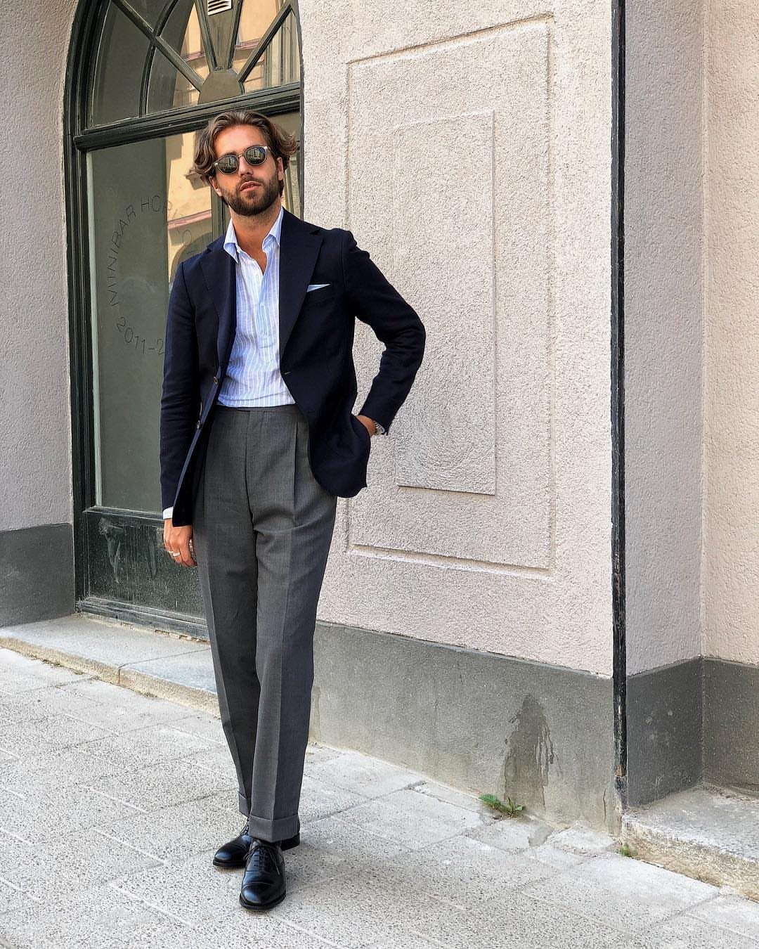 Man in navy blazer and grey trousers wearing polished black oxford shoes