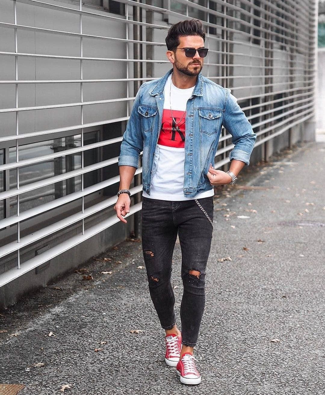 Man wearing red sneakers, black ripped skinny jeans, and a blue denim jacket.