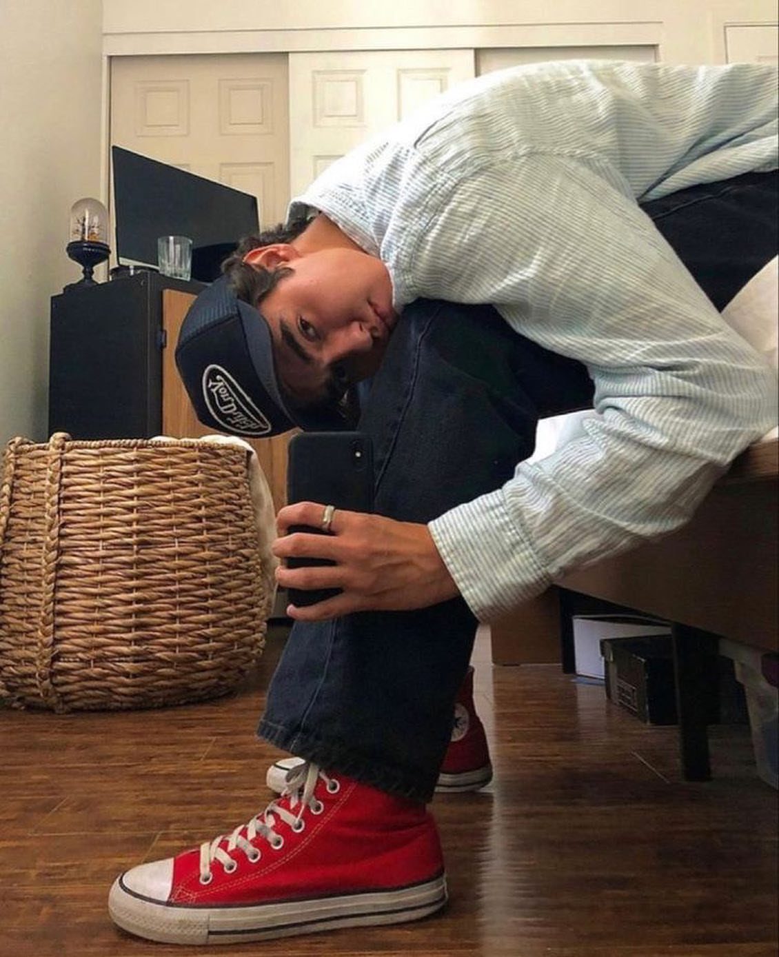 Person wearing red high-top sneakers with a light blue shirt and dark jeans.