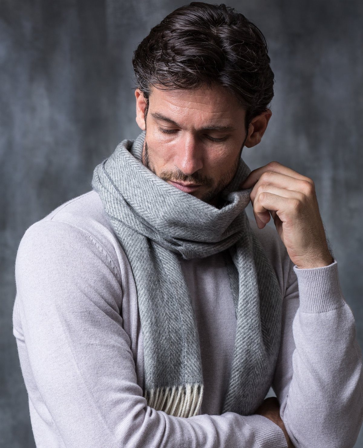 Man wearing a grey wool scarf wrapped in a one loop style.