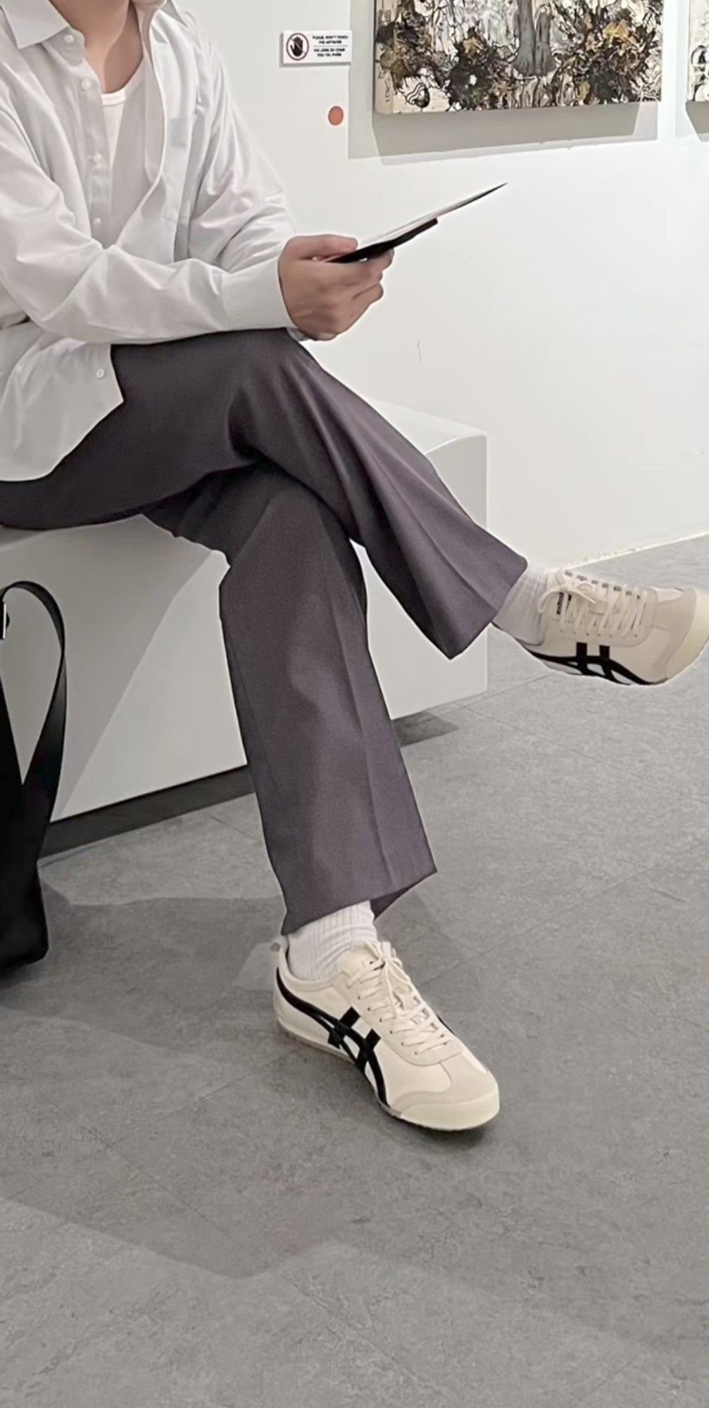 Person wearing white shirt, grey wide-leg trousers, and cream Onitsuka Tiger sneakers.