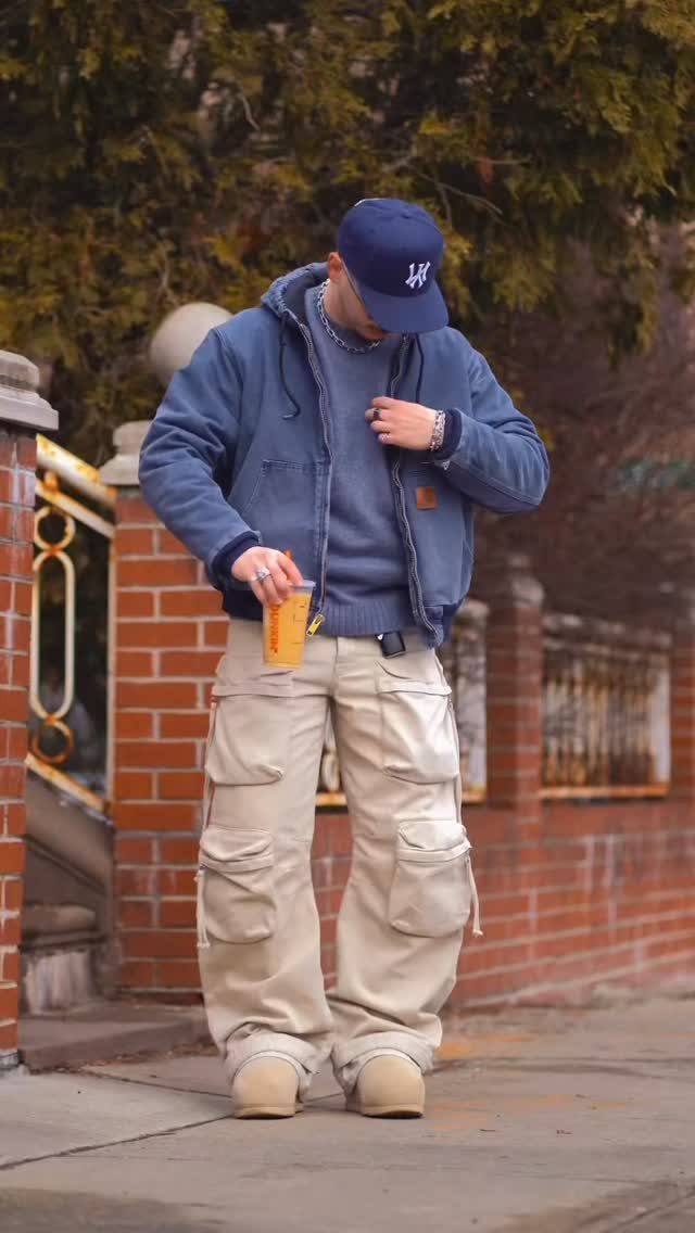 Person wearing a blue hoodie, beige cargo pants, and tan winter boots outdoors.