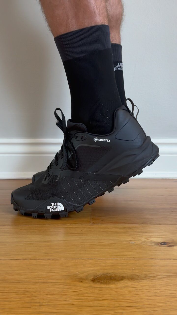 Black The North Face trail running shoes with Gore-Tex on a wooden floor.